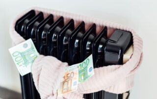 Kaloryfer owinięty szalem z banknotami symbolizuje rozliczenie ciepła w mieszkaniach.